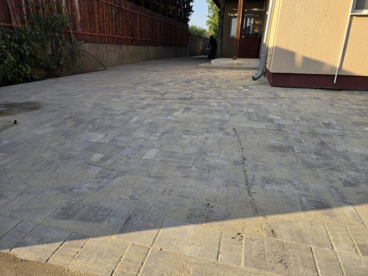 Large-format grey blended paved yard beside a house